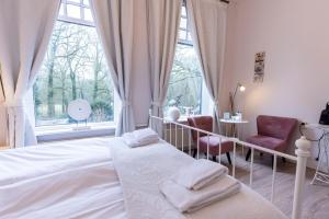 een slaapkamer met een bed, een raam en een stoel bij Bed & Breakfast Rijsterbosch in Rijs