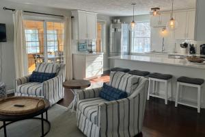 sala de estar con 2 sillas y cocina en Patrician Shores Beach Abode, en Meredith