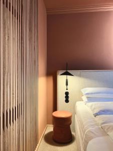 ADELANTE Boutique Hotel في برلين: غرفة نوم مع سرير وكرسي بجوار مصباح