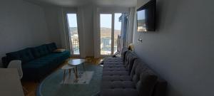 a living room with a couch and a glass table at Apartman GOLD in Bjelašnica