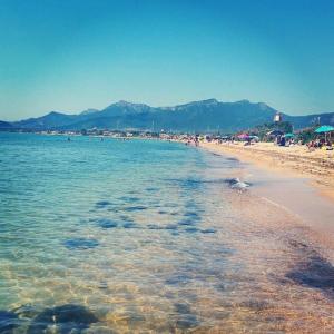 a beach with a bunch of people in the water at La Maddalena spiaggia 80mt dal mare Lido di Capoterra in Capoterra