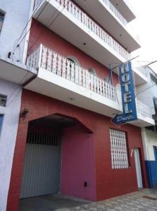 ein rotes Gebäude mit einer Tür und einem Balkon in der Unterkunft Hotel Dueto in São Bernardo do Campo