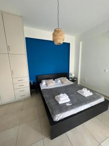 sypialnia z łóżkiem z niebieskim zagłówkiem w obiekcie Blue and White w mieście Schinias