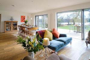 uma sala de estar com um sofá azul e uma mesa em Lowlands em Thorpeness