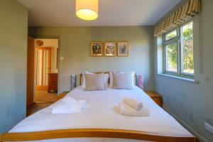 a bedroom with a large white bed with towels on it at Lowlands in Thorpeness