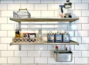 a kitchen with three shelves on a white tiled wall at Spacious Industrial style Apartment in London