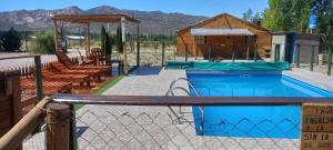 a swimming pool with a gazebo and a house at Aires del Montura in Uspallata