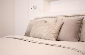 a bed with white pillows and a white wall at Spacious Industrial style Apartment in London
