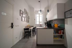a kitchen with white cabinets and a table with chairs at Veniero37 Guest House in Rome +29 photos
