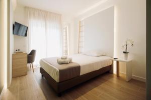 a bedroom with a bed and a desk and a chair at Hotel Olivò in Bitritto
