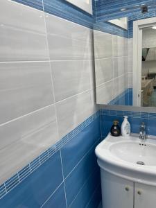 un bagno blu e bianco con lavandino e specchio di Mare e Sole a Maiori