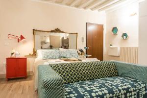 Un dormitorio con una cama, un sofá y un espejo. en Reggio Center Lovely Apartments, en Reggio Emilia