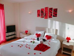 Un dormitorio con una cama con corazones rojos. en Cintray Parc Résidence en Breteuil-sur-Iton