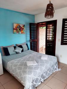 1 dormitorio con cama y pared azul en Pousada dos Anjos Paracuru, en Paracuru