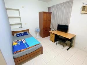 a bedroom with a bed and a desk and a computer at 南朋友 不收現金 Cash not accepted未收到匯款以前房間一概不保留 詳情請參閱圖片加line聯繫 謝謝 in Tainan