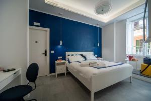 a bedroom with a blue accent wall and a bed at Veniero37 Guest House in Rome