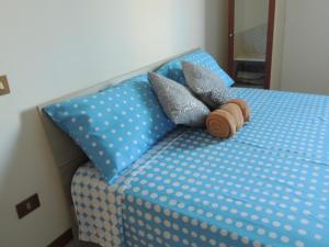 a bed with blue polka dot sheets and pillows at Il Chicco apartment in Lamporecchio