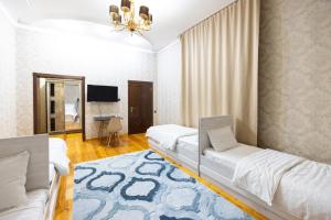 um quarto de hotel com duas camas e uma televisão em Central Park em Tashkent