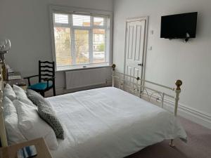 a bedroom with a white bed and a flat screen tv at Hotel 50 in Bournemouth