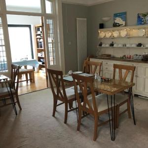 a dining room with a table and chairs and a kitchen at Hotel 50 in Bournemouth