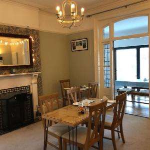 a dining room with a table and chairs and a fireplace at Hotel 50 in Bournemouth