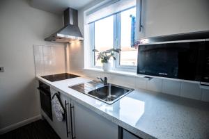 a kitchen counter with a sink and a window at Town House Chantry - With Self Check In and Free Parking - Rooms at ipswichdigs in Ipswich