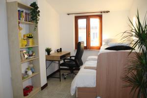 a bedroom with a bed and a desk with a chair at Confortevole appartamento a Roma FREE PARKING in Castel di Leva