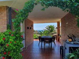 d'une terrasse avec une table, des chaises et un mur en briques. dans l'établissement Villa Playa, à L'Ametlla de Mar