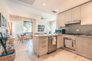 a kitchen with white cabinets and a table with chairs at Newly Added 1BR El Portillo Luxury in Portillo