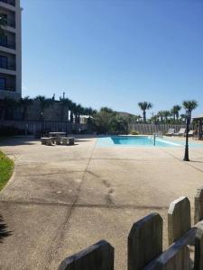 a park with a swimming pool with benches and a building at Paradise PRN in Gulf Shores