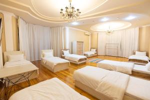 Cette chambre comprend 3 lits et un lustre. dans l'établissement Central Park, à Tachkent
