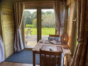 a dining room with a table and a sliding glass door at Silver Springs Farm Lodge in Dingestow
