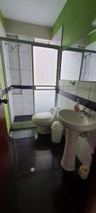 La salle de bains est pourvue d'un lavabo et de toilettes. dans l'établissement Apartamento Acogedor, à Huancayo