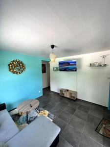ein Wohnzimmer mit einem Sofa und einer blauen Wand in der Unterkunft VillaCalmflor in Sainte-Anne