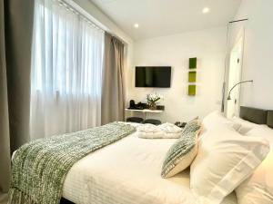 - une chambre avec un lit et une télévision murale dans l'établissement Le Muraine, à Bergame