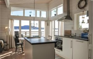 a kitchen with a island in a room with windows at Awesome Home In Åmotfors With Wifi in Åmotsfors