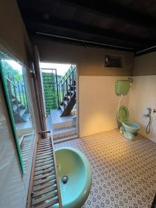 a bathroom with a green sink and a toilet at Kejora Homestay in Kangar