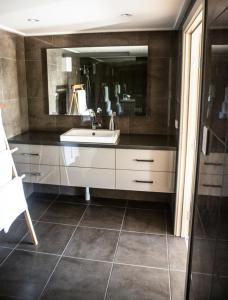 un baño con lavabo y espejo en Dairyman's Cottage, en Lyndoch
