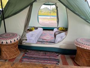 uma tenda verde e branca com duas camas em Kejora Homestay em Kangar
