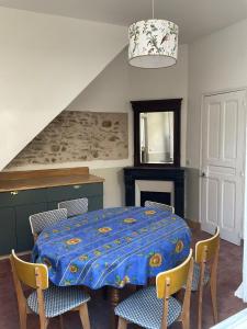 una sala da pranzo con tavolo e sedie blu di Jolie maison 6 couchages proche Versailles a La Celle-Saint-Cloud