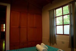 1 dormitorio con cama y ventana grande en Casanicca Habitaciones privadas en Casa Compartida en San Martín de los Andes