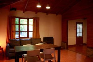 sala de estar con mesa y sofá en Casanicca Habitaciones privadas en Casa Compartida en San Martín de los Andes