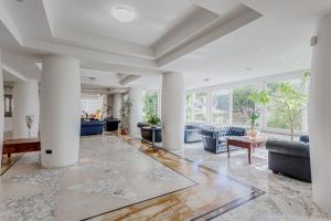 an open living room with columns and couches at Hotel Cavalluccio Marino in Santa Marinella