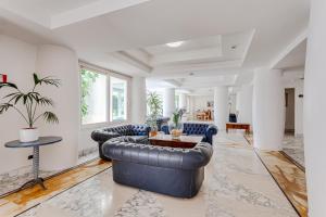 a living room with two leather couches and a table at Hotel Cavalluccio Marino in Santa Marinella