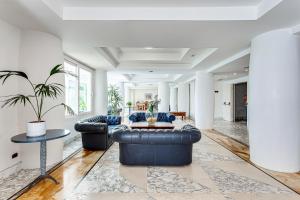 a living room with two leather couches and a table at Hotel Cavalluccio Marino in Santa Marinella