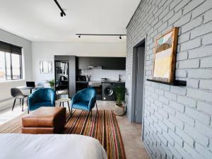 a room with a bed and a kitchen with a brick wall at Apartment 4023-stunning views in Sandton in Johannesburg