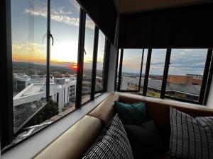 a living room with a couch in front of a large window at Apartment 4023-stunning views in Sandton in Johannesburg