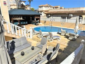 un patio con sillas y una piscina en 2 Apts in Villa Sun and Happiness, en San Miguel de Salinas