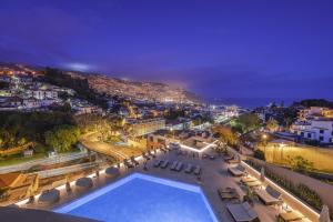 a view of a city at night with a swimming pool at The Views Baia - Adults Only in Funchal