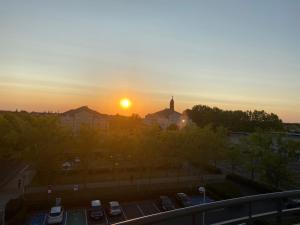 a sunset over a parking lot with cars parked at Résidence Meublée Disney et Paris in Bussy-Saint-Georges